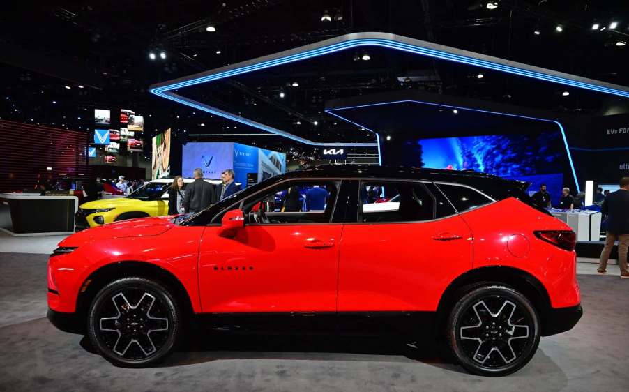 2023 Red Chevrolet Blazer at an auto show from the side.