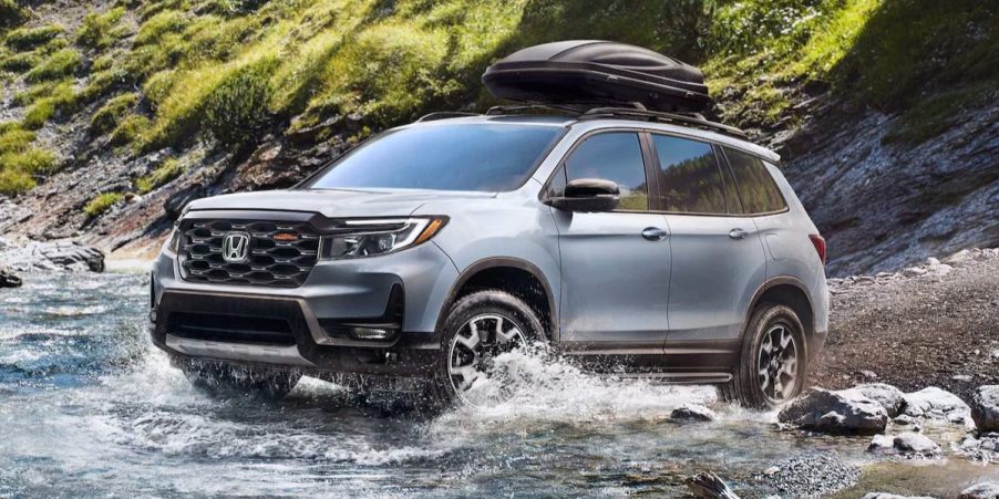 A gray 2023 Honda Passport midsize SUV is driving off-road.