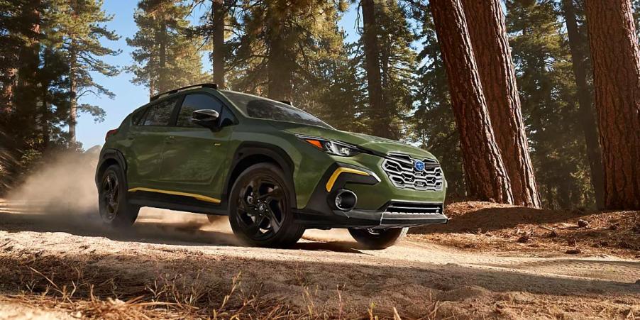 A green Subaru Crosstrek subcompact SUV is driving off-road.