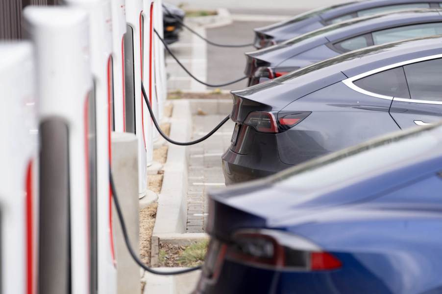 A line of EVs hooked up to public DC fast chargers.