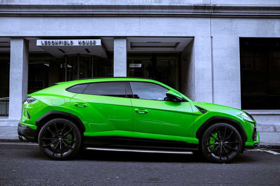 A Green Lamborghini Urus parked on a street