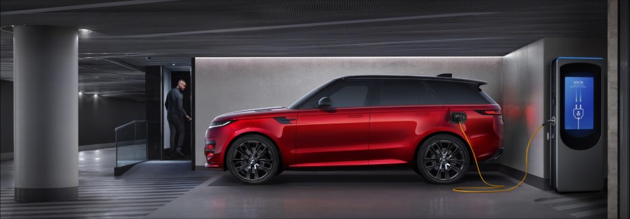 A red Range Rover Sport PHEV plugged in to charge.