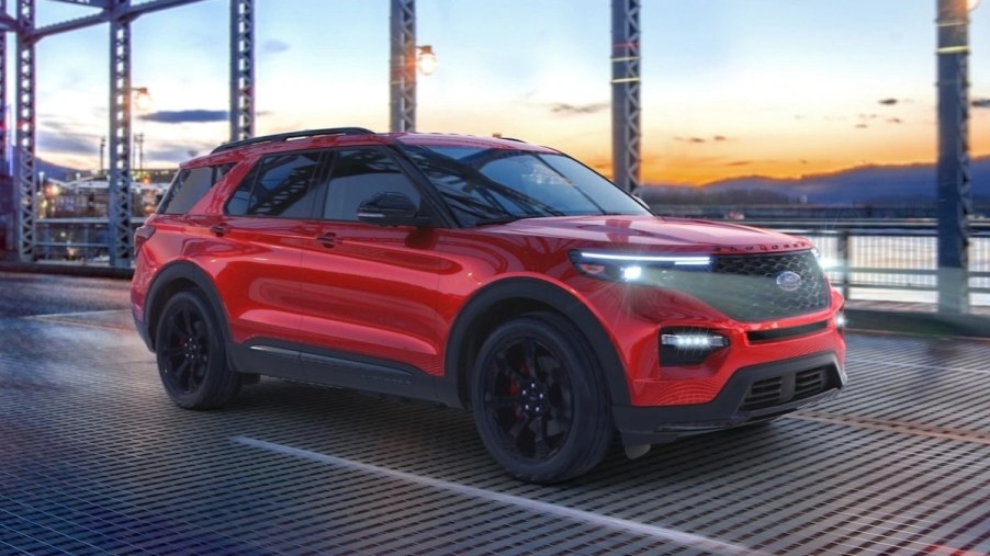 Red 2023 Ford Explorer midsize SUV driving over a bridge