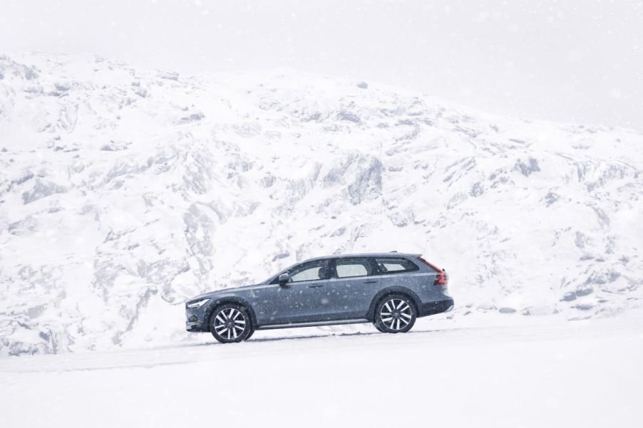 A 2023 Volvo V90 Cross Country in Thunder Grey driving near snowy mountains