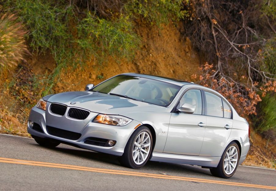 A used silver 2007 BMW 335i cruises around a hilltop.