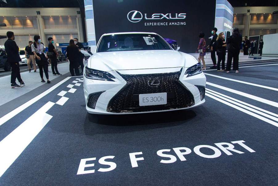 A white 2022 Lexus ES, parked on a blacktop area with ES F Sport printed on the ground, which is also one of the safest Lexus cars of 2022.