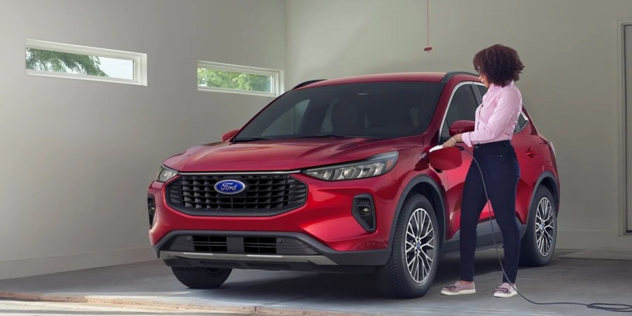 A red 2023 Ford Escape Plug-In Hybrid SUV is being charged.