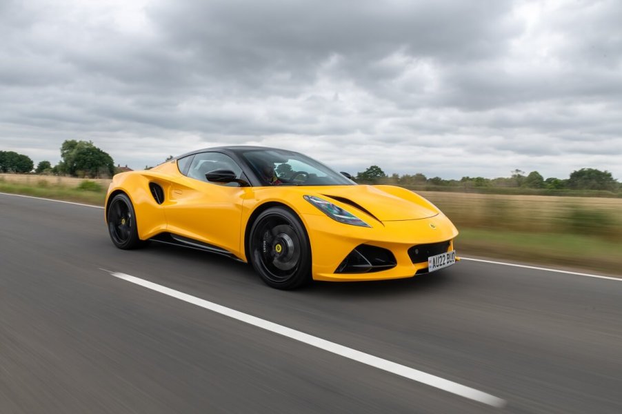 A bright yellow 2023 Lotus Emira model shows off its fascia on a country road.