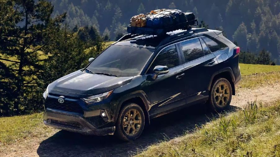 Black 2023 Toyota RAV4 compact crossover SUV driving off-road