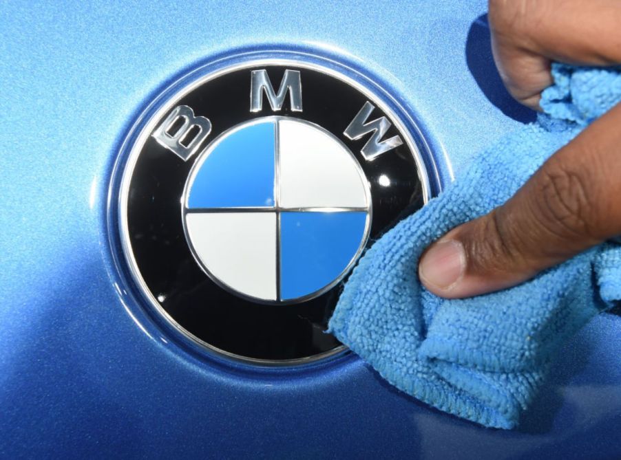 A person wipes a BMW logo with a cloth.