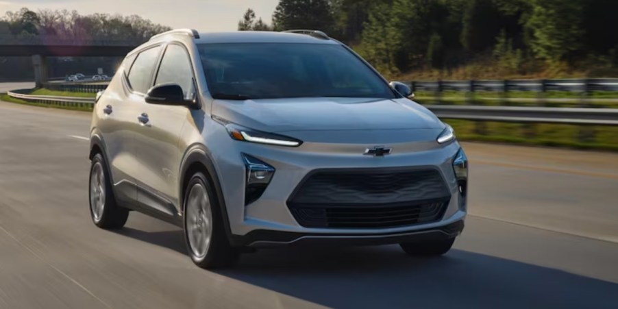 A gray 2023 Chevrolet Bolt EUV subcompact electric SUV is driving on the road.