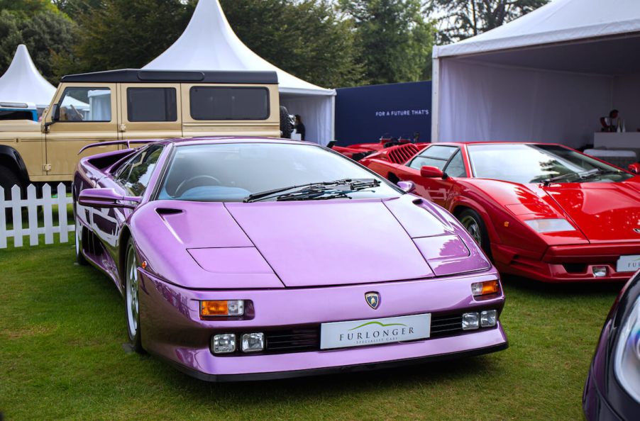 A pink 1995 Lamborghini Diablo parked in the grass