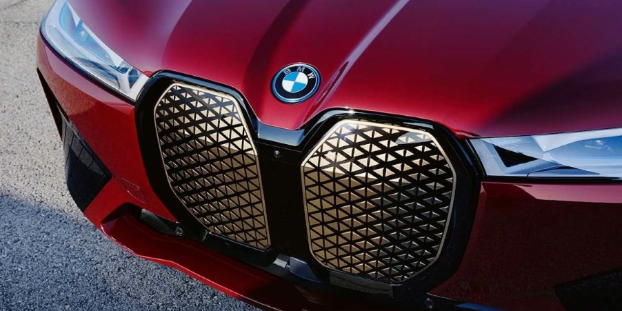 The front of a red 2024 BMW iX midsize electric SUV.