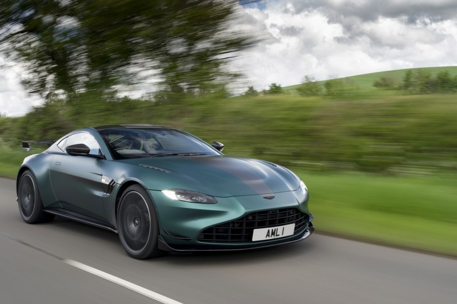 A green 2023 Aston Martin Vantage on a green hillside road