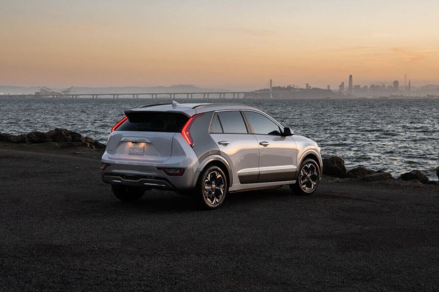 A silver 2023 Kia Niro EV parked on the shore at dusk.