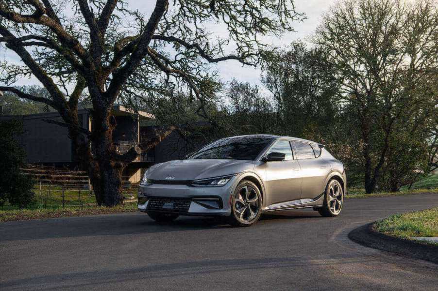 A silver 2023 Kia EV6 parked in front of a few trees in the country.