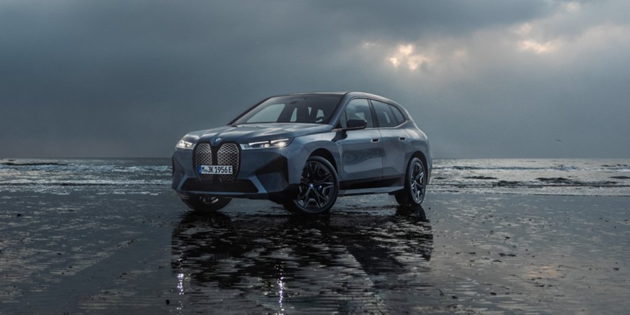 A blue 2024 BMW iX midsize luxury electric SUV is parked.