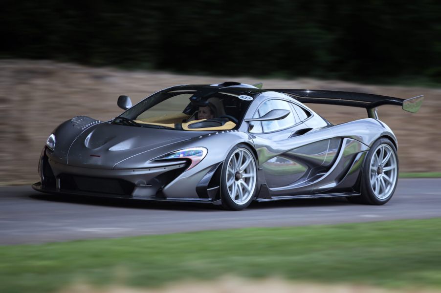 A silver McLaren P1 HDK racecar driving on a country road