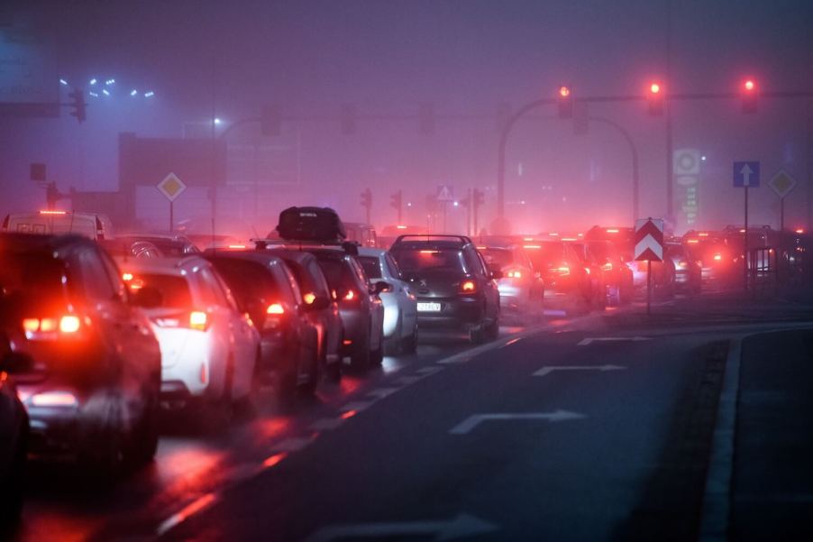 Bumper-to-bumper traffic waits on the interstate, tail lights illuminating the fog.