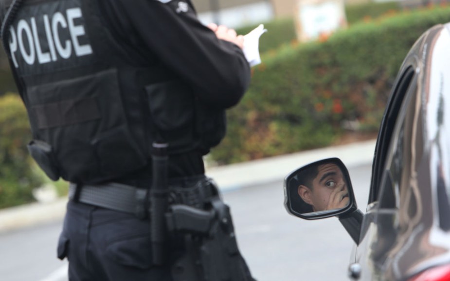 A policeman writting a ticket for a simple traffic mistake