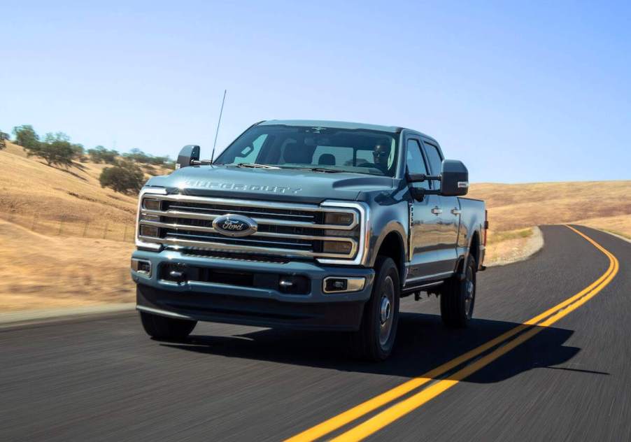 A fully loaded 2023 Ford F-350 Limited travels on a two-lane rural highway