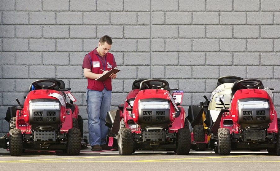 An employee inventories lawn mowers at a Lowes store.