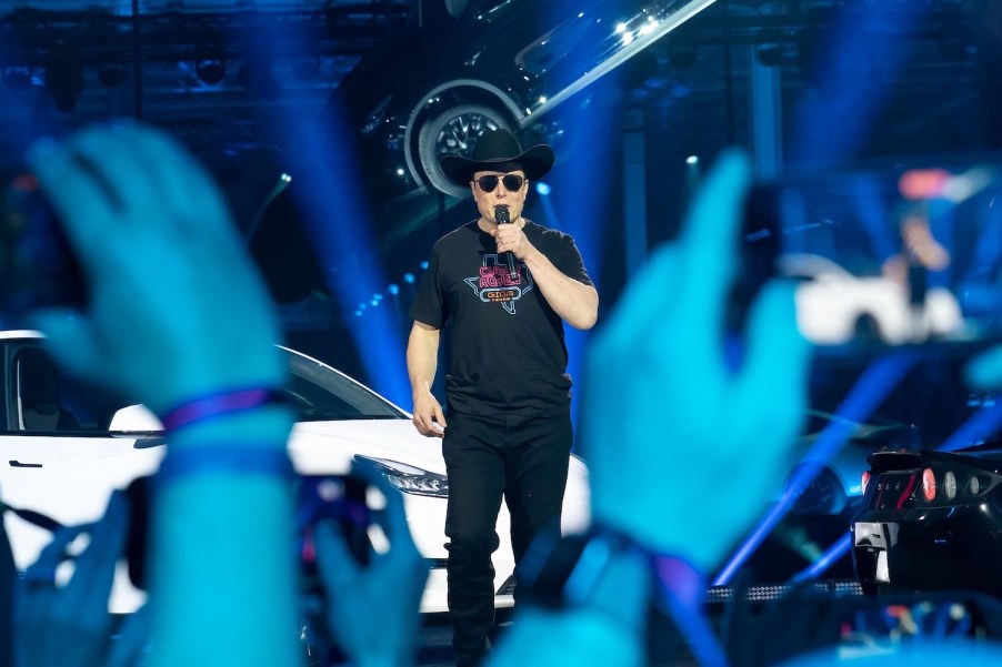 Tesla's co-founder and CEO Elon Musk speaks at his Cyber Rodeo while launching Texas Giga factory, the audience visible in the foreground.