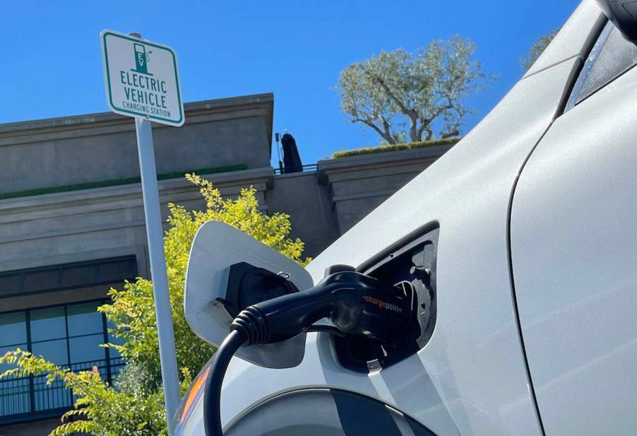 A close-up shot of an electric car plugged into a charger.