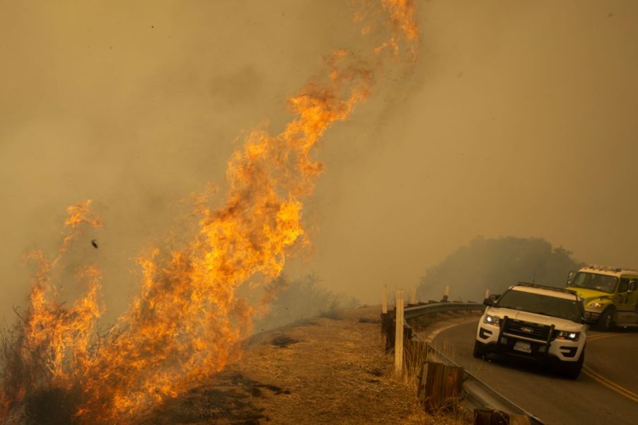 Kern County Sheriffs near flames from the French Fire on State Route 155 in Wofford Heights, California