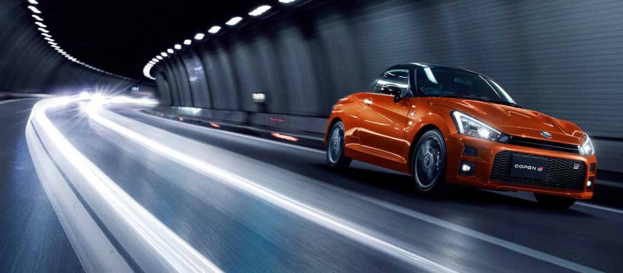 Toyota Daihatsu Copen GR Sport Convertible driving through a tunnel at night in bright orange sports car