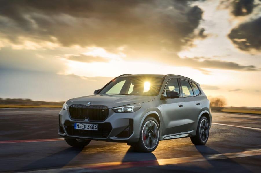 A BMW X1 M35i xDrive subcompact SUV model in Frozen Pure Grey Metallic with a sunset behind it