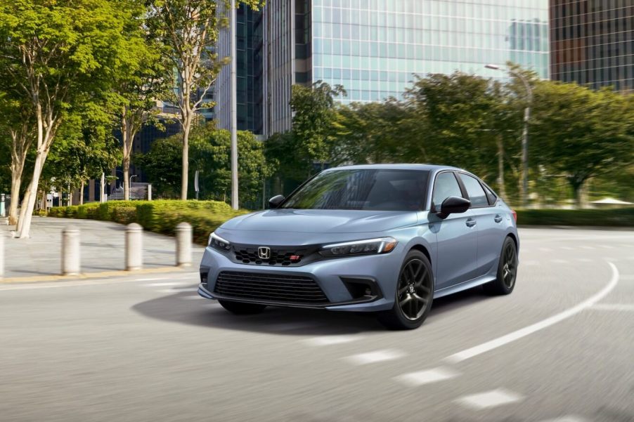 A silver Honda Civic sedan driving on a city road.