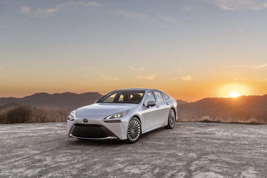 A white 2023 Toyota Mirai parked on a cliff at sunset. This Toyota SUV is off to a rough start in sales this year.