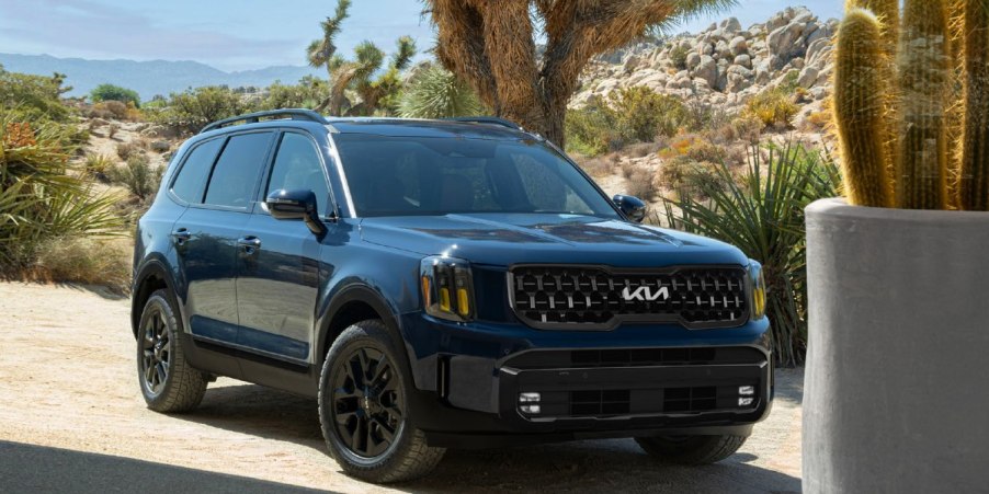 A blue 2024 Kia Telluride midsize SUV is parked outdoors.