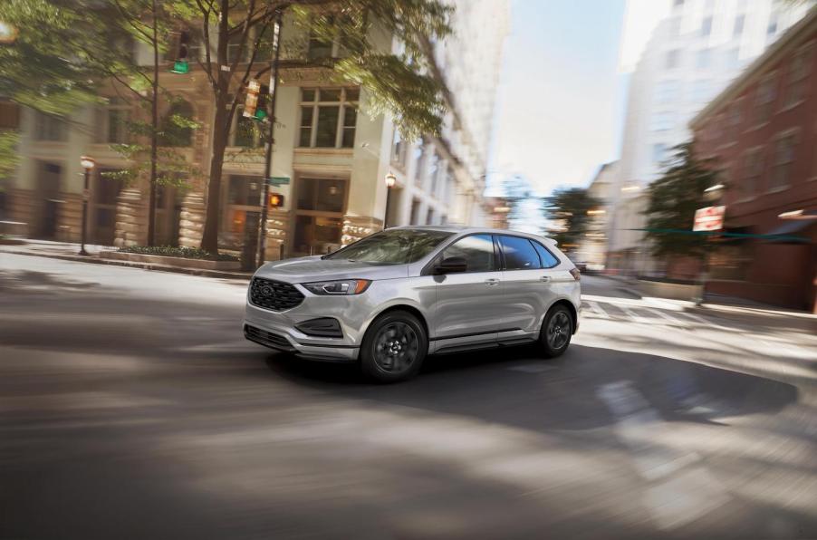 A silver Ford Edge taking a turn on a city road. The last Ford Edge comes in 2024 before the model fades out of production.