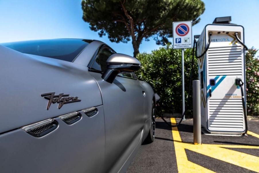 The all-electric Maserati GranTurismo Folgore grand tourer coupe model plugged into a charging station