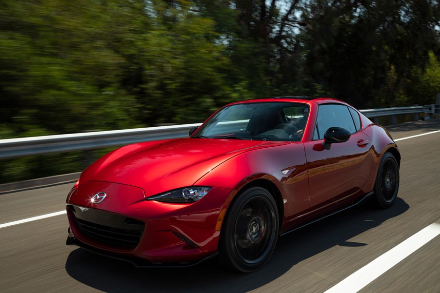 Front 3/4 of a Mazda MX-5 Miata driving down a highway