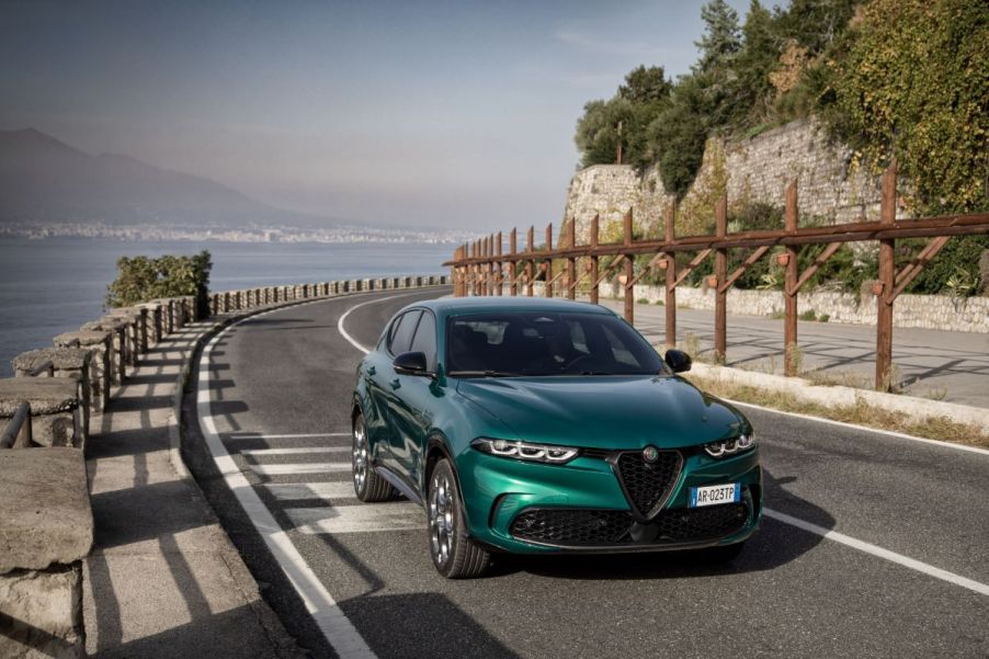 A 2024 Alfa Romeo Tonale PHEV model driving on a seaside highway road