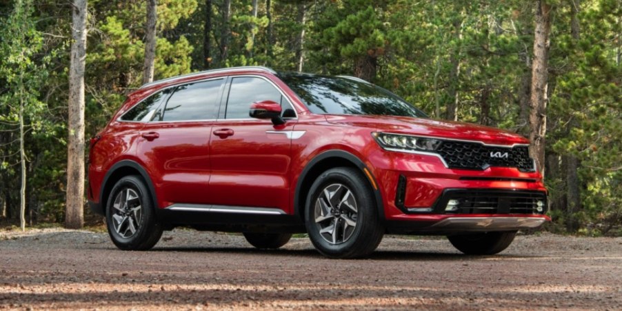 A red 2023 Kia Sorento Hybrid midsize hybrid SUV is parked outdoors.