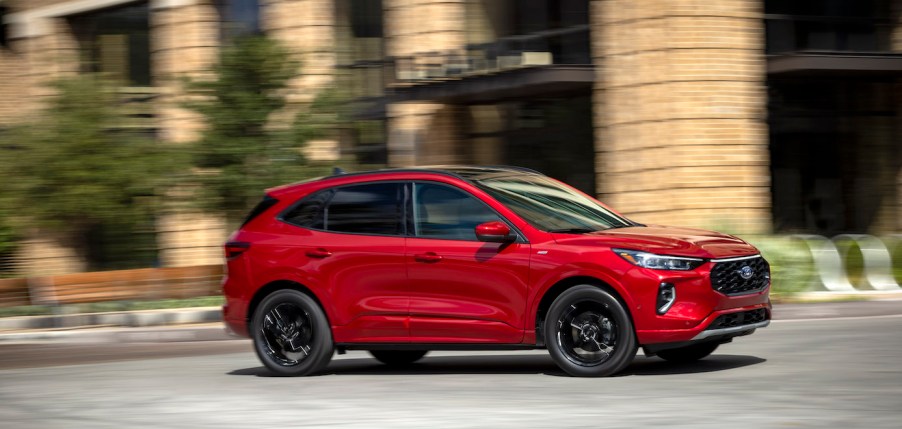 A red pre-production 2023 Ford Escape driving on a city road. Ford Escape sales numbers are actually pretty high.