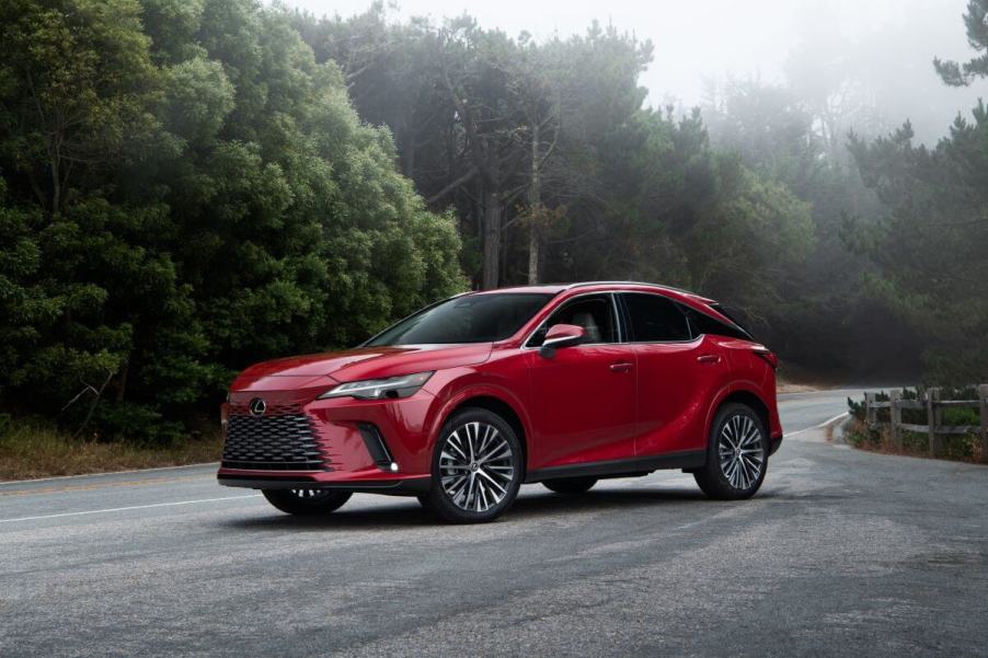 A 2024 Lexus RX 350h midsize luxury SUV model parked on a forest road covered in fog