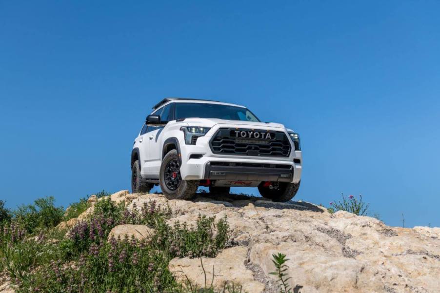 A 2024 Toyota Sequoia TRD-Pro midsize SUV model parked on a rocky hill covered in purple flowers