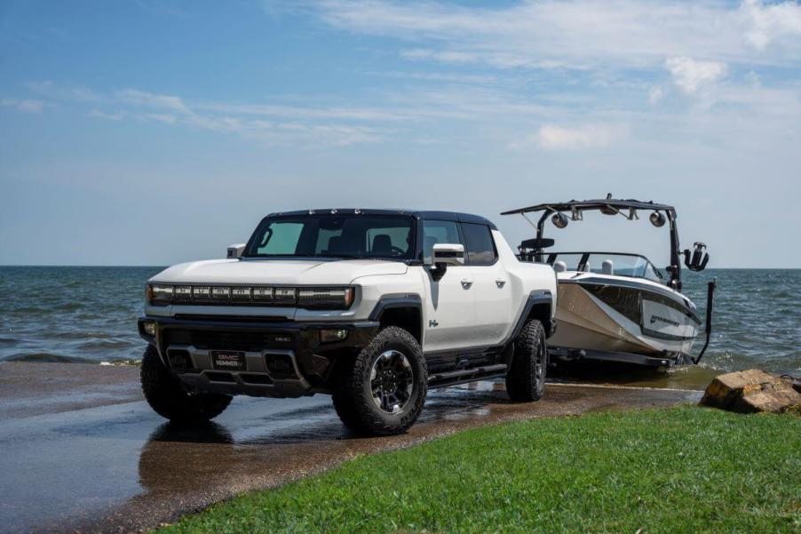 A 2023 GMC Hummer EV Edition 1 full-size all-electric pickup truck model towing a boat out of the water