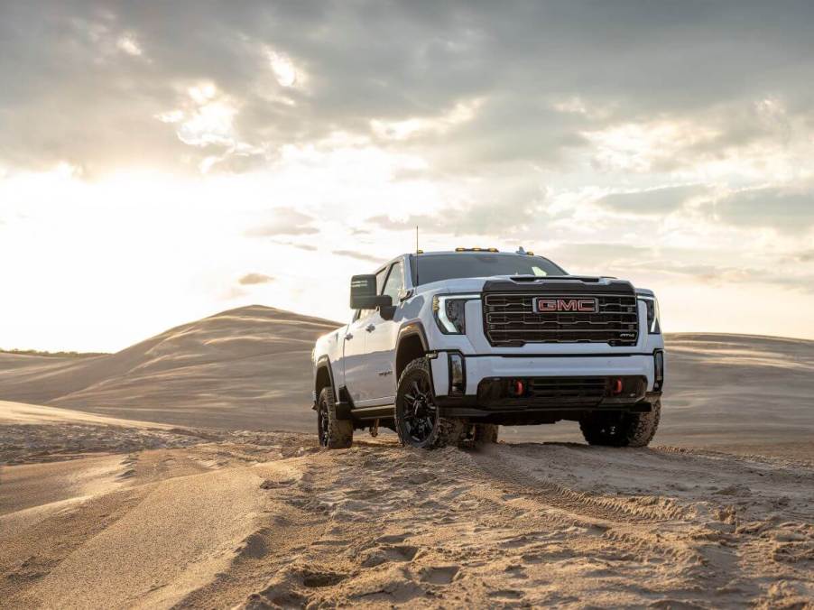 A 2024 GMC Sierra 2500 HD AT4 heavy-duty, all-terrain pickup truck model traversing a desert