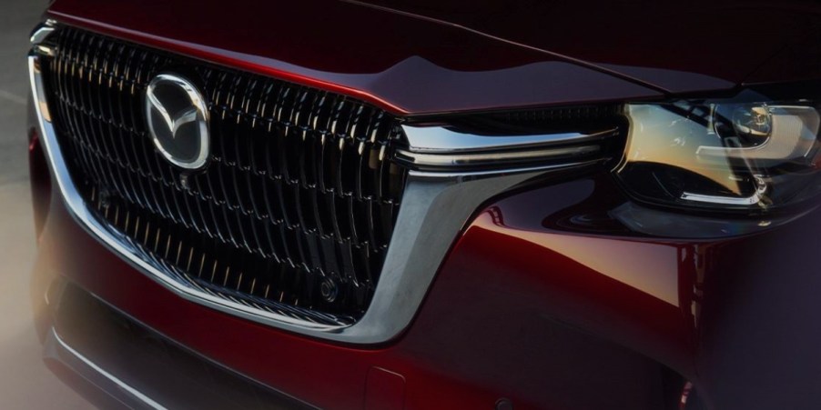 The front of a red 2024 Mazda CX-90 midsize three-row SUV.