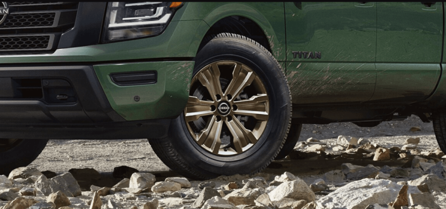 A close up a bronze wheel on a mud-spattered 2024 Nissan Titan Bronze Edition full-size pickup truck