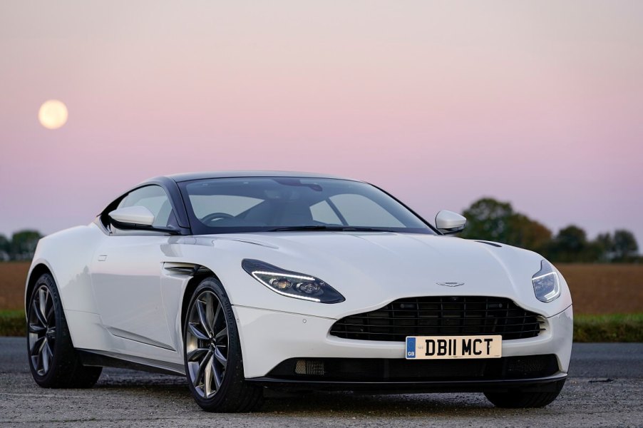 A white Aston Martin DB11, like Nathan Shelley's in 'Ted Lasso,' sits under a sunset.