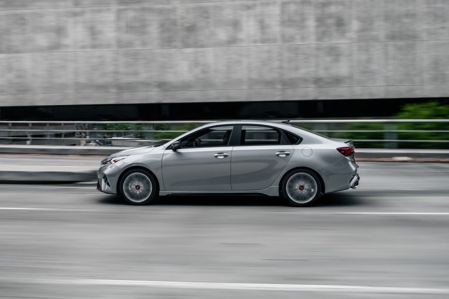 A 2023 Kia Forte driving down a city street.