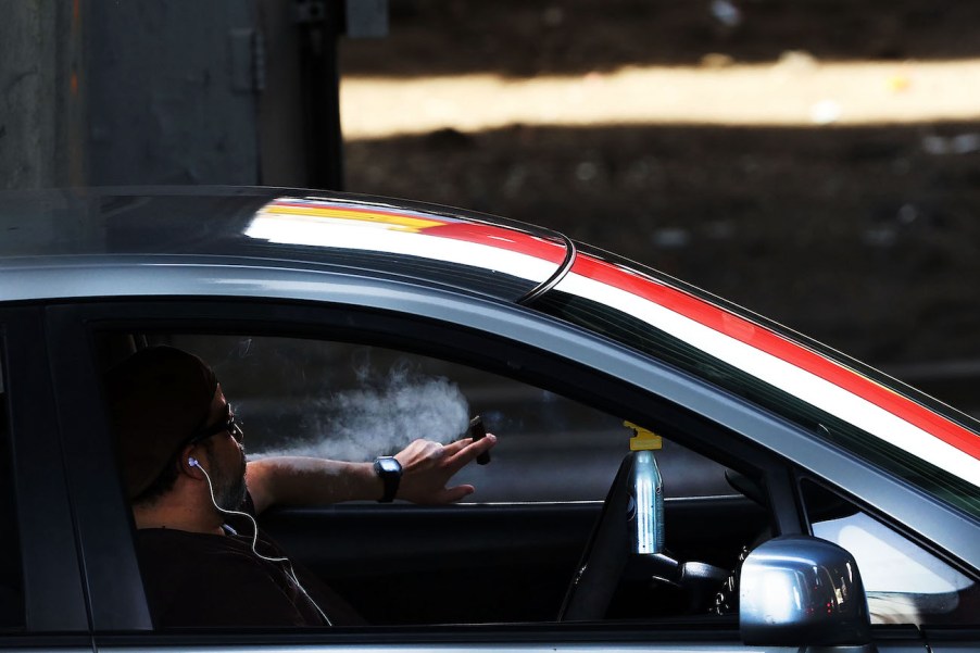 A driver pauses with a cigar while behind the wheel on April 30, 2016 in New York, New York. Do smoking laws prohibit this?