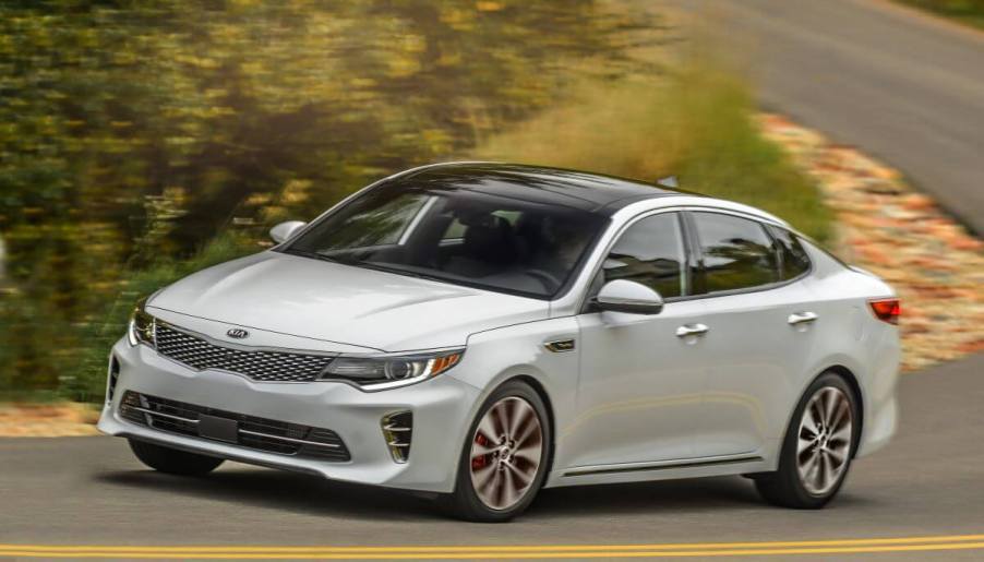 A 2017 Kia Optima SXL midsize sedan model cornering on a country highway